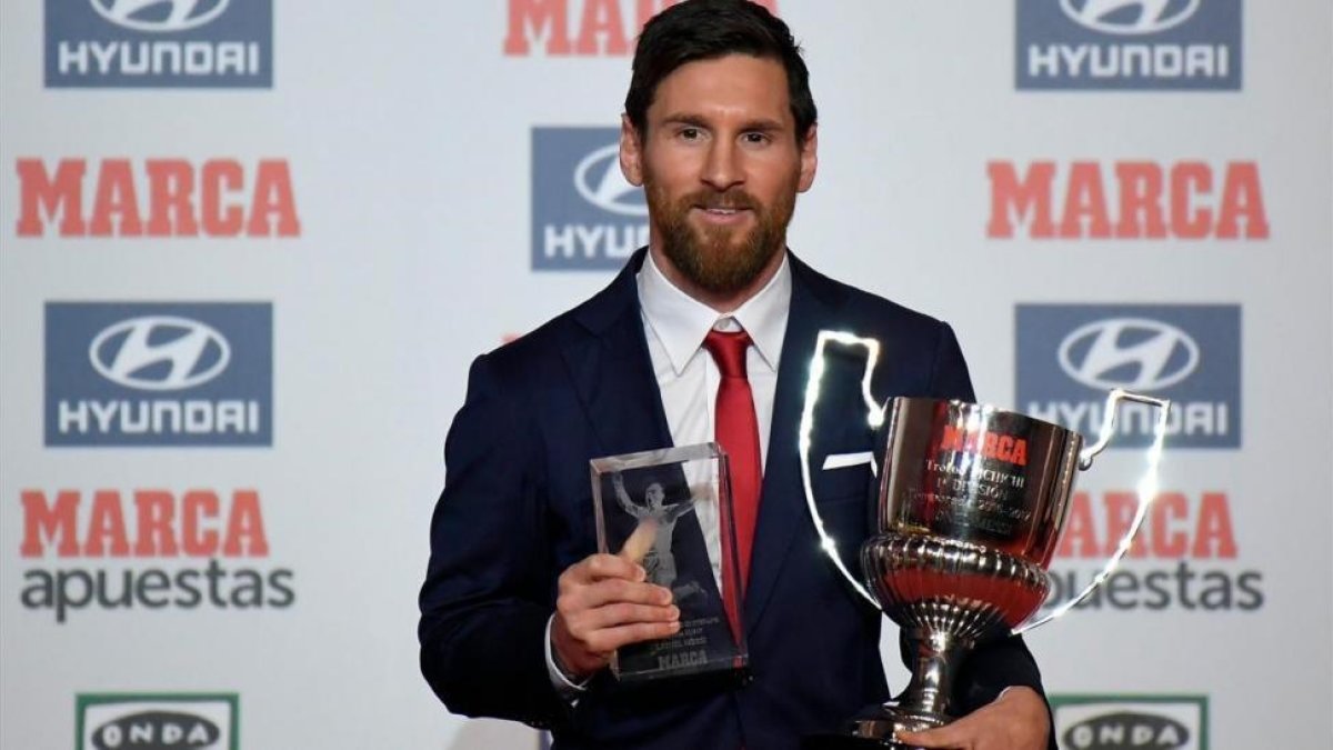 Messi, con el trofeo Pichichi y el trofeo Di Stéfano, que le entregó el diario Marca.-AFP / LLUIS GENE