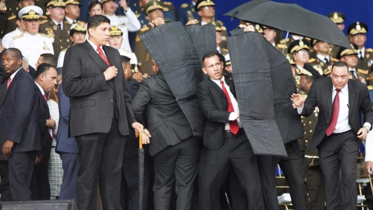 Personal de seguridad protege a Nicolás Maduro tras el atentado con drones en Venezuela. /-AP / XINHUA