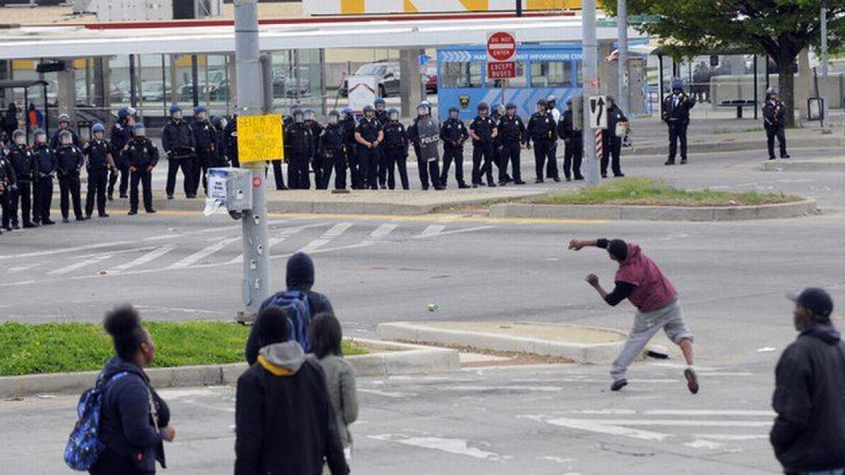 Unos manifestantes lanzan objetos a la policía, el lunes en Baltimore.-Foto: AP / LLOYD FOX