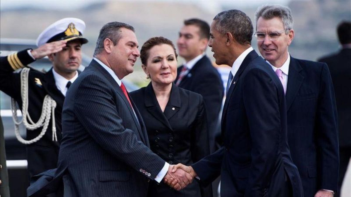 Obama, a su llegada al aeropuerto de Atenas, donde ha sido recibido por el ministro griego de Defensa, Panagiotis Kommenos.-BRENDAN SMIALOWSKI