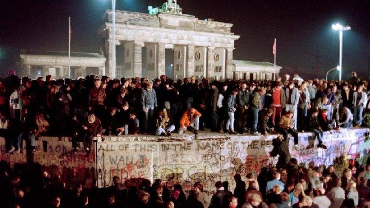 Centenares de alemanes orientales suben al muro cerca de la Puerta de Brandenburgo, el 11 de noviembre de 1989.-GERARD MALIE (AFP)