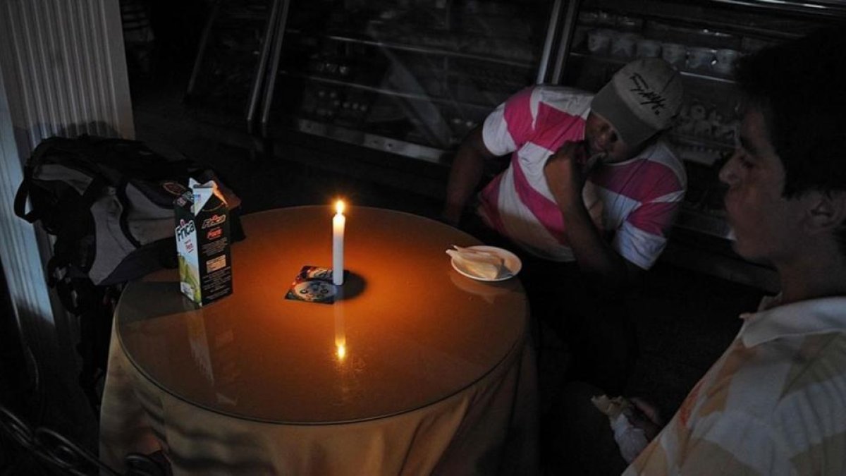 Hombres sentados en una panadería en San Cristóbal, a 600 kilómetros al oeste de Caracas, el 25 de abril.-AFP / GEORGE CASTELLANOS