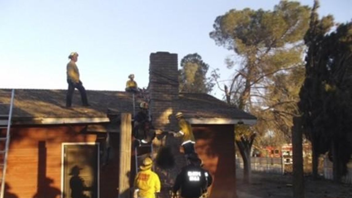 Los bomberos, tras desmontar la chimenea para rescatar el cadáver del presunto ladrón, en Fresno (California).-REUTERS