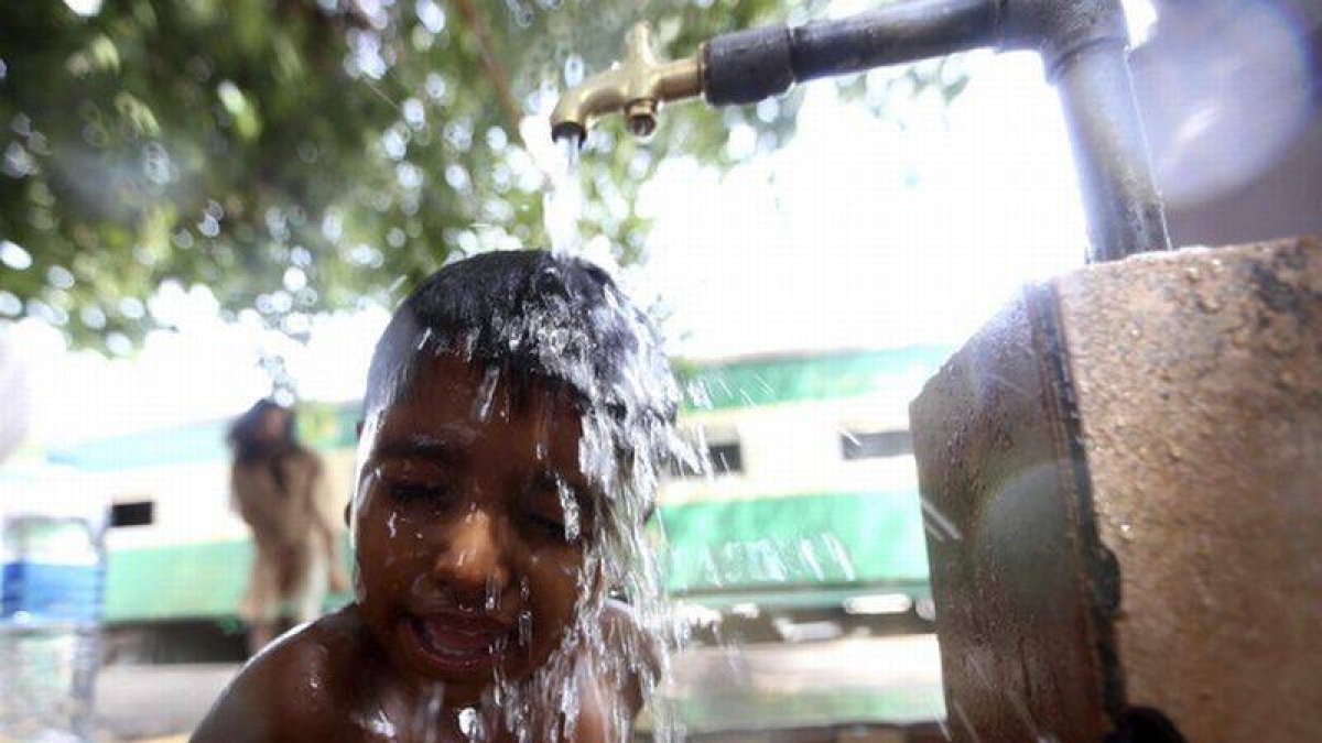 Un niño se refresca en un caluroso día en Karachi, Pakistán.-Foto: EFE / REHAN KHAN