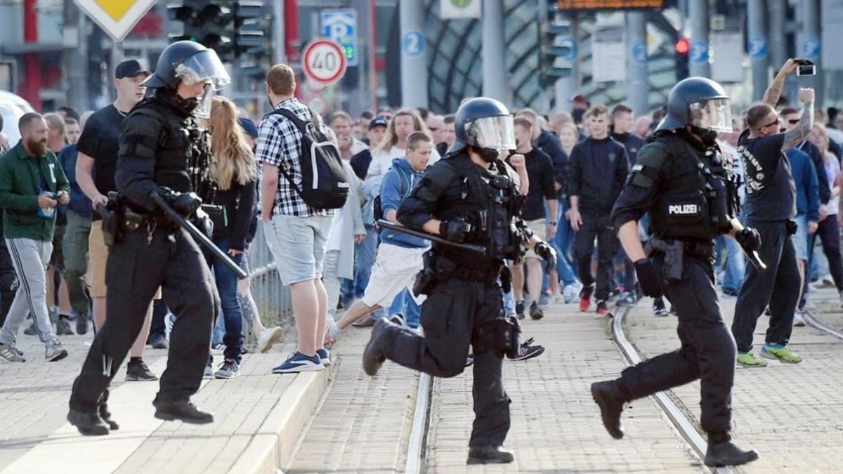 La policía alemana cruzando la calle en Chemnitz durante la polémica manifestación de caza de extranjeros. /-ANDREAS SEIDEL