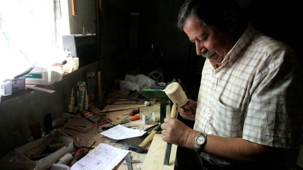 El artista Félix Morán en el taller donde realiza maquetas de aperos de labranza en la localidad leonesa de Fresno de la Vega. ICAL-