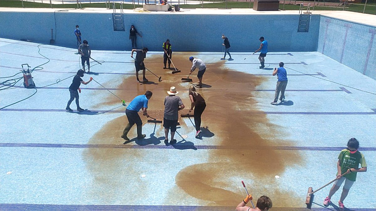Vecinos de Bayubas de Abajo limpiando de lodo su piscina en la mañana del sábado.-HDS