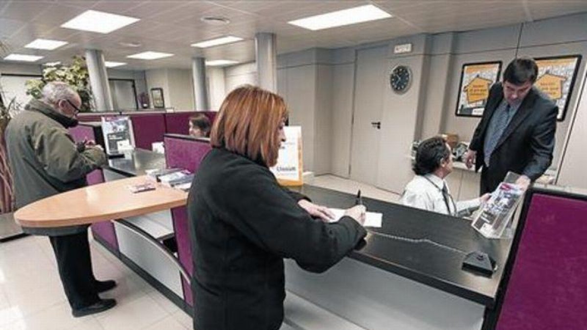 Una clienta realiza una gestión en una oficina bancaria en Tona (Osona).-JOSEP GARCIA
