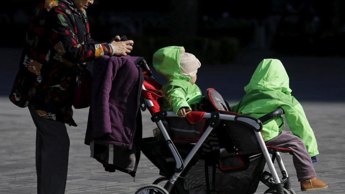 Una mujer con dos niños en Pékin, China. /-KIM KYUNG-HOON (REUTERS)