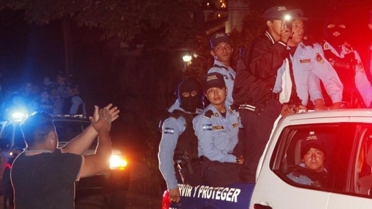 Vecinos de Tegucigalpa aplauden al paso de policías que se niegan a aplicar el estado de emergencia.-/ FERNANDO ANTONIO / AP