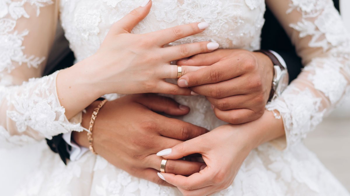 Dos novios muestran sus anillos de boda. HDS