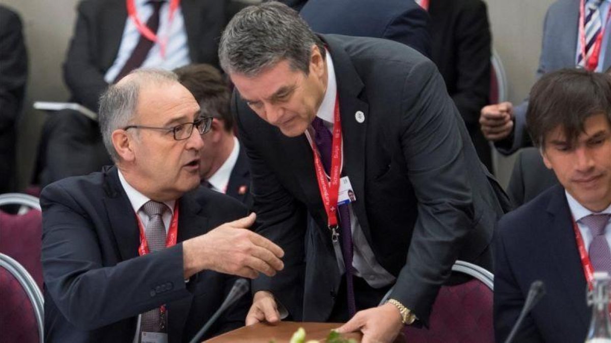 El consejero Federal de Suiza de Comercio Guy Parmelin, sentado, conversa con el director general de la Organizacion Mundial del Comercio, Roberto Azevedo, en el Foro de Davos.-EL PERIÓDICO