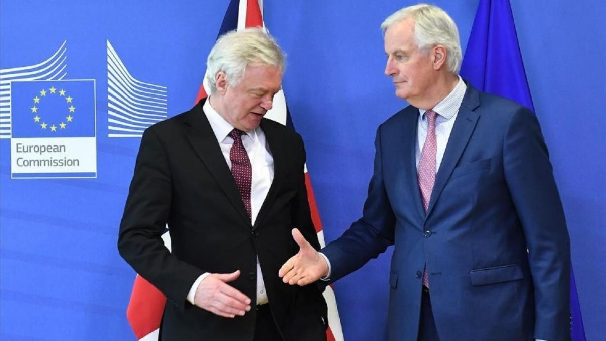 Michel Barnier tiende la mano a David Davis en la sede de la Comisión Europea, en Bruselas.-AFP