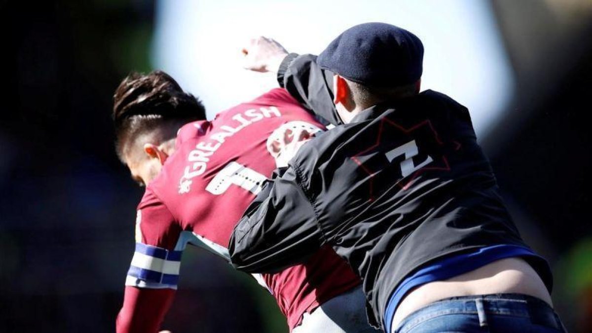 Momento en el que el aficionado golpea a John Grealish.-EL PERIÓDICO