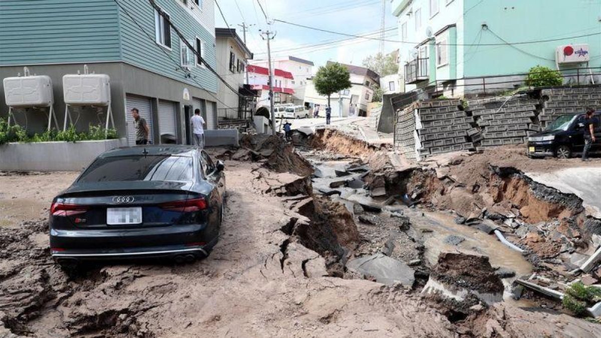 Un vehiculo permanece atrapado entre el lodo en una calle destruida tras el fuerte terremoto.-JIJI PRESS (EFE)