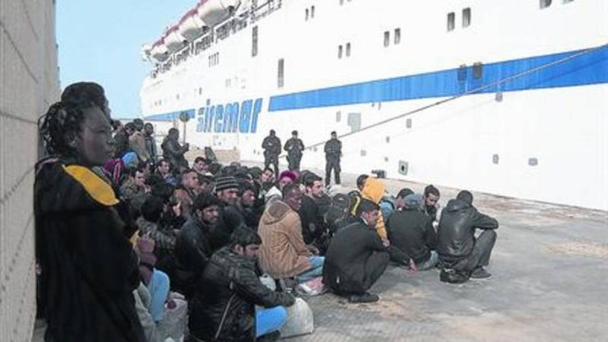 Grupos de inmigrantes esperan a ser trasladados desde Lampedusa a Sicilia.-Foto: ANA ALBA