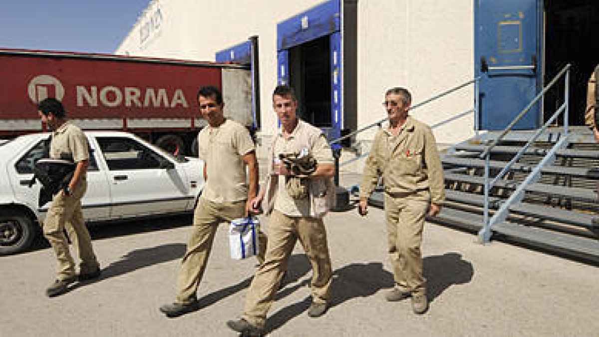Trabajadores de Norma saliendo ayer de la fábrica./ V. G. -