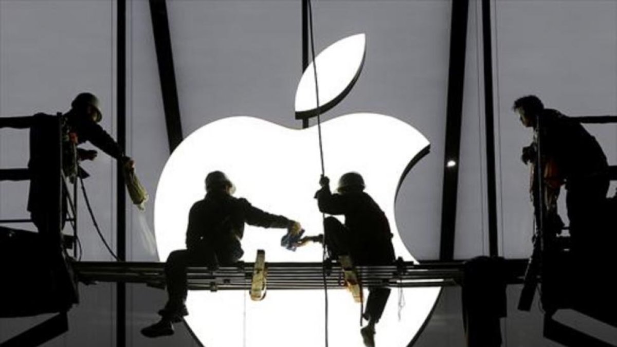 Varios operarios ultiman los trabajos antes de la apertura de una nueva tienda de Apple.-REUTERS / CHANCE CHAN