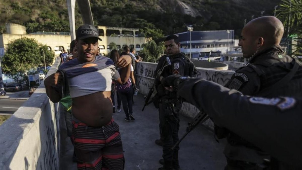 Agentes de la policia patrullan frente a la favela Rocinha durante una marcha de los habitantes pidiendo paz, el jueves 19 de octubre de 2017 , en Río de Janeiro, Brasil.-EFE / ANTONIO LACERDA