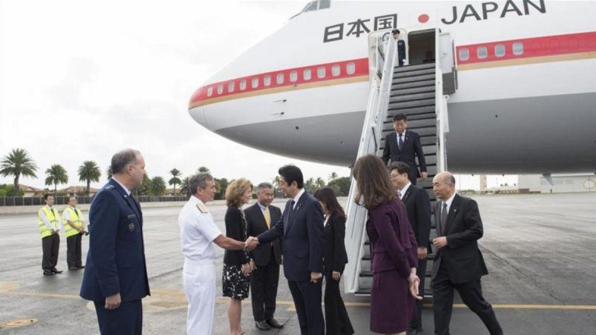El primer ministro japones, Shinzo Abe, en el centro, es recibido por un comandante estadounidensse a su llegada a Pearl Harbor.-EFE / JAY CHU