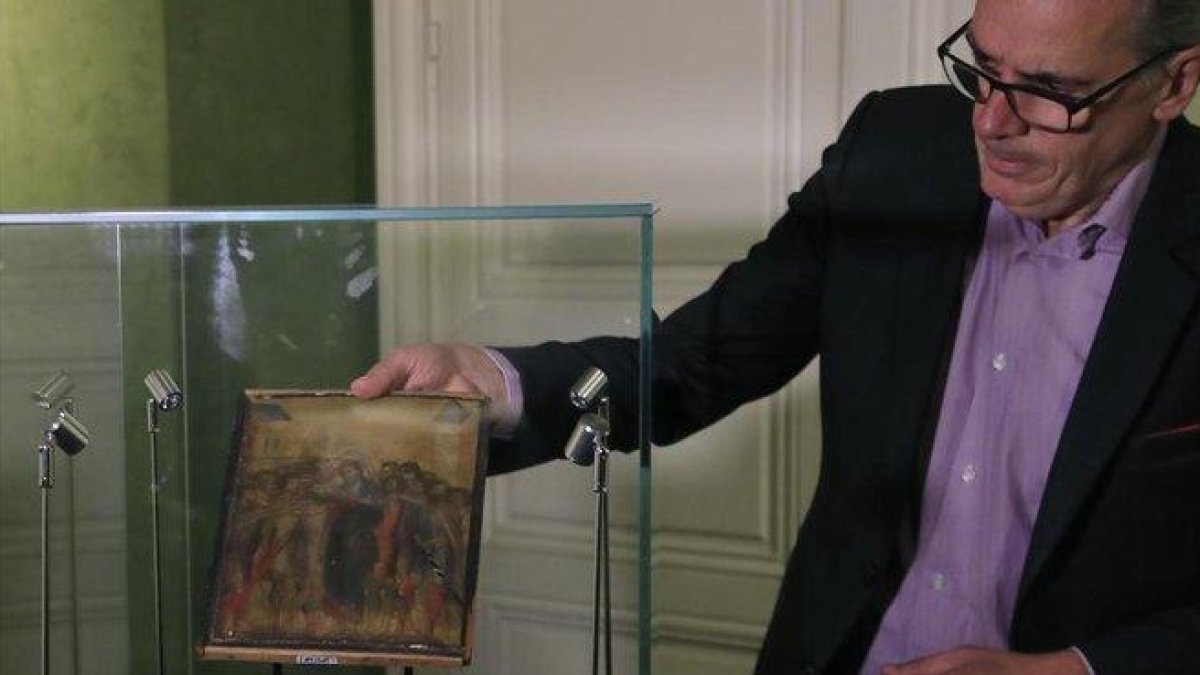 Un experto muestra el cuadro de Cimabue subastado en París.-AP / MICHEL EULER