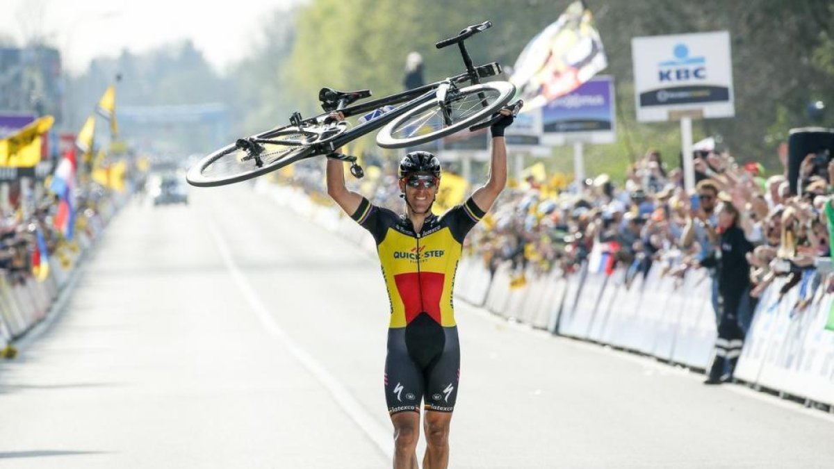 Philippe Gilbert cruza la meta de Flandes con la bici a cuestas.-JULIEN WARNAND