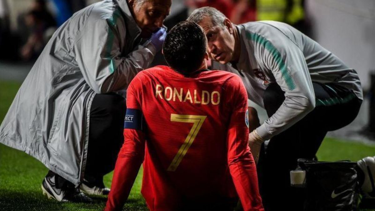 Cristiano Ronaldo, atendido tras la lesión.-AFP / PATRICIA DE MELO