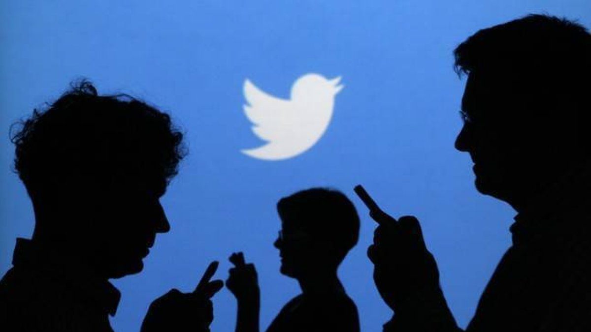 Siluetas de gente con el móvil, con el logo de Twitter al fondo.-Foto:   REUTERS / KACPER PEMPEL