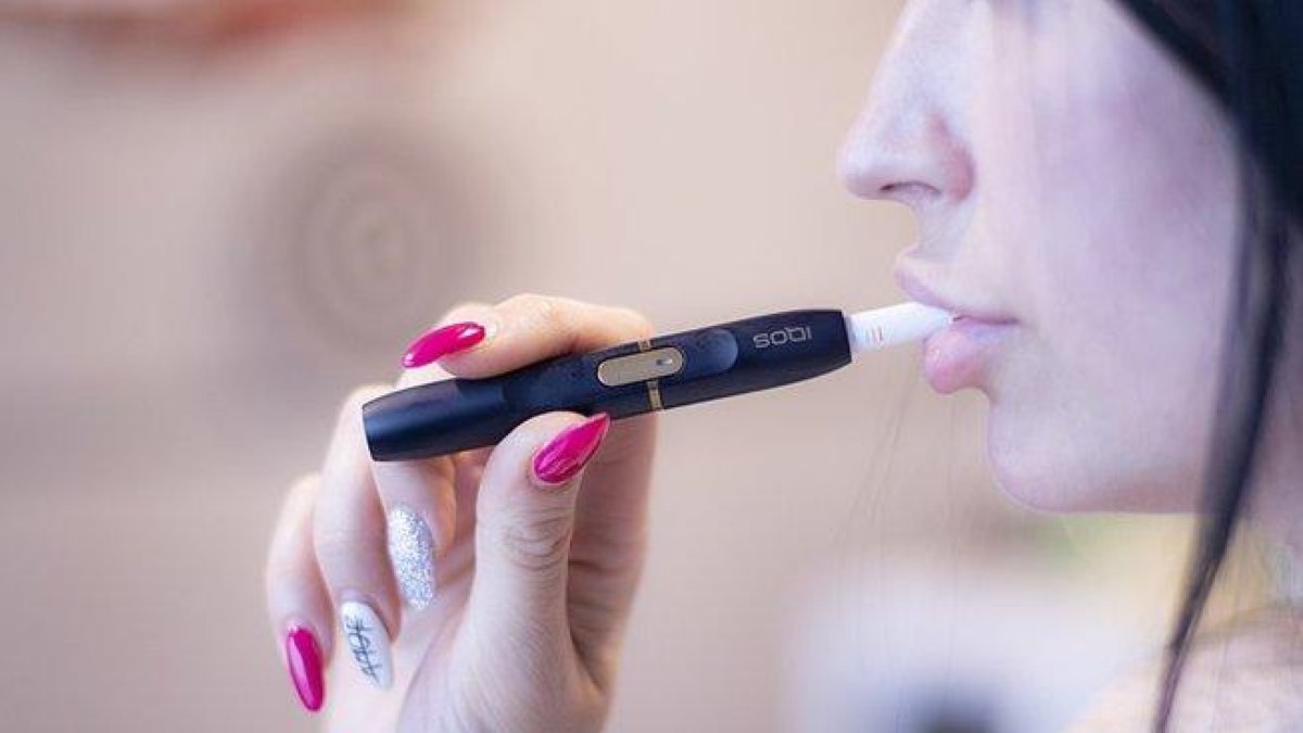 Una chica fuma con el dispositivo IQOS de Philip Morris.-