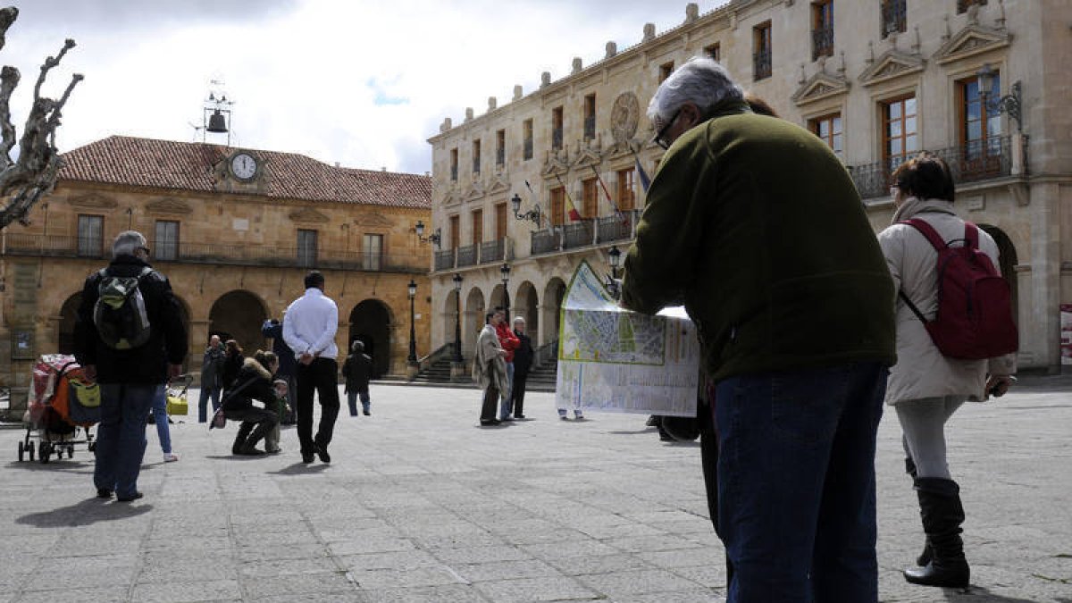 Turistas en la plaza Mayor de la capital consultando un mapa. / ÁLVARO MARTÍNEZ-