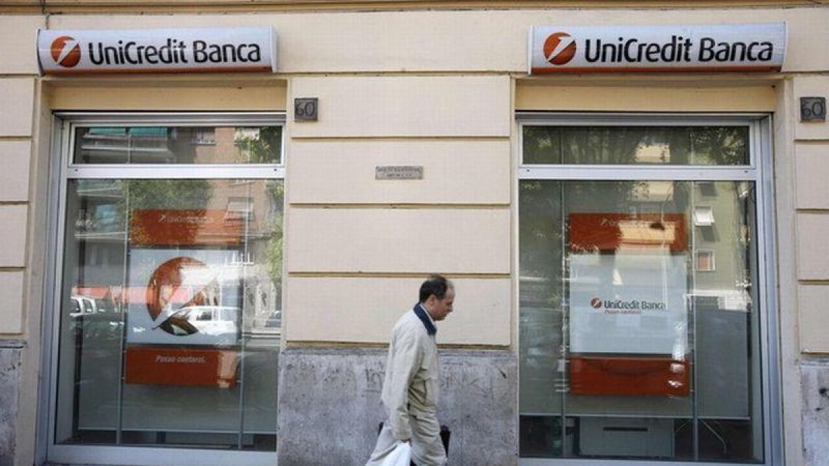 Un hombre pasa frente a una oficina de Unicredit en Milán.-DARIO PIGNATELLI / REUTERS
