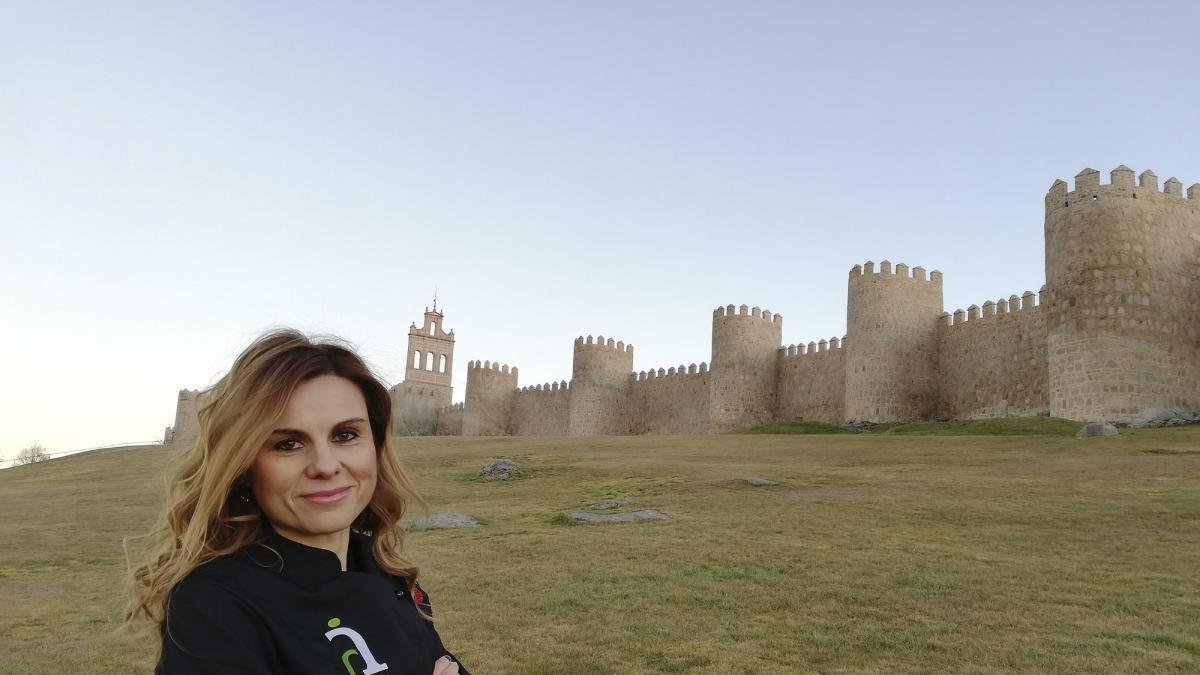 Gemma Rodríguez, ataviada con un delantal de Ávila Auténtica, delante de la imponente muralla romana abulense. --