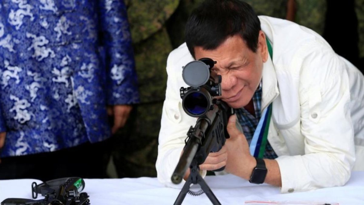 Duterte comprueba la mirilla de un rifle, hace unos días.-REUTERS / ROMEO RANOCO