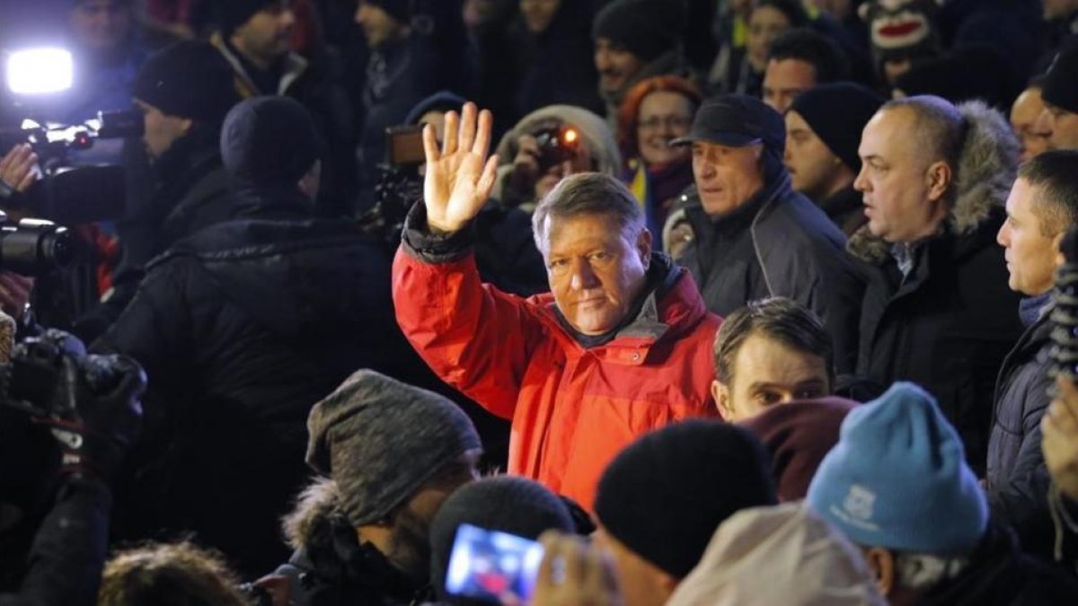 Klaus Iohannis (centro) saluda a los manifestantes en una concentración contra el Gobierno, en Bucarest, el 22 de enero.-EFE / ROBERT GHEMENT