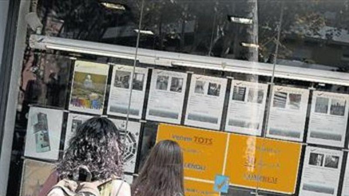 Anuncios de pisos en venta en una inmobiliaria de Barcelona.-FERRAN NADEU