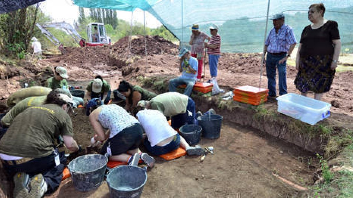 Descendientes y vecinos de Barcones observan los trabajos en la fosa mientras la excavadora busca el segundo enterramiento. / ÁLVARO MARTÍNEZ-