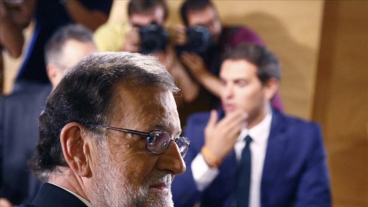 El presidente del Gobierno en funciones y líder del PP, Mariano Rajoy, en la firma del pacto de investidura con el jefe de Ciudadanos, Albert Rivera.-AGUSTÍN CATALÁN