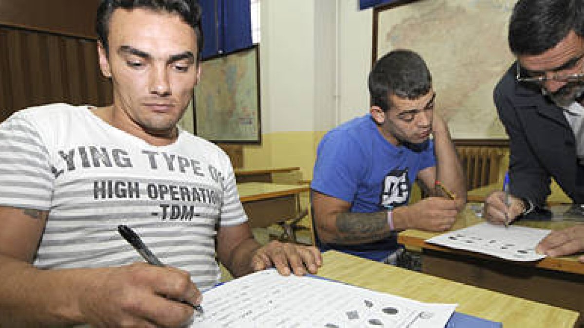 Los presos de origen rumano Marcel y Adrian asistieron ayer a su primera clase del curso con el profesor Pepe. / VALENTÍN GUISANDE-