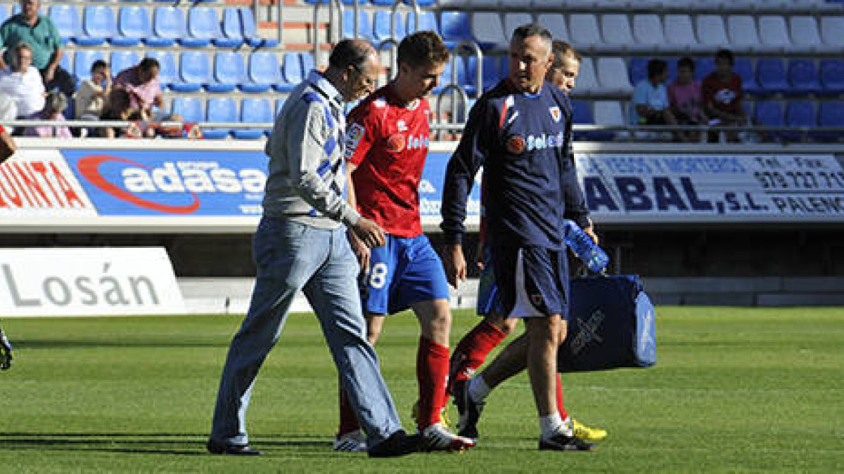 Vicente abandona el terreno de juego ayudado por Patxi Bedia e Ignacio Arche. / DIEGO MAYOR-