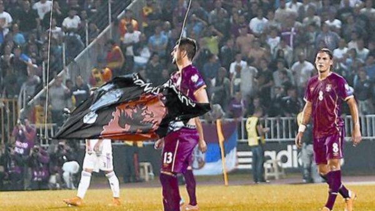 Mitrovic recoge la bandera que colgaba del dron que sobrevoló el estadio del Partizán.-Foto: EFE / SRDJAN SUKI