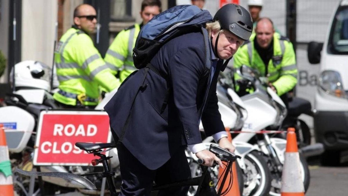 El exalcalde de Londres Boris Johnson, abanderado del 'brexit', conduce su bici por el centro de Londres, este miércoles.-AFP / DANIEL LEAL-OLIVAS