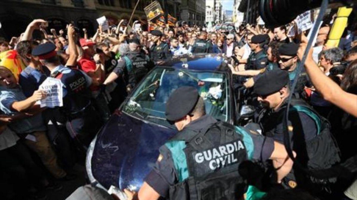 Mossos ayudan a guardias civiles a salir de una concentración de protesta ante la Conselleria dAfers Exteriors.-FERRAN NADEU