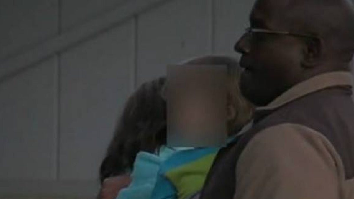 Un policía lleva al niño de 3 años que ha matado a su madre accidentalmente.-