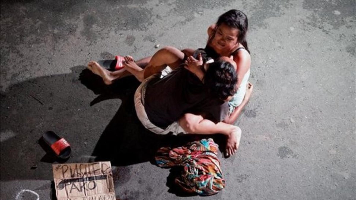 Jennelyn Olaires, de 26 años, abraza a su esposo Michael Siaron, de 30, abatido el sábado 23 de julio en Manila por civiles sin identificar.-REUTERS / CZAR DANCEL