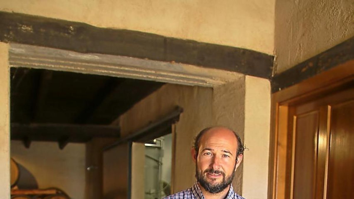 El enólogo Ildefonso Gregorio Hidalgo posa en la entrada de la bodega con sus vinos.-M.T.