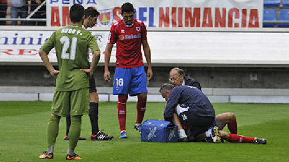 Antonio Tomás es atendido por los servicios médicos del Numancia tras su lesión ante el Sporting. / DIEGO MAYOR-