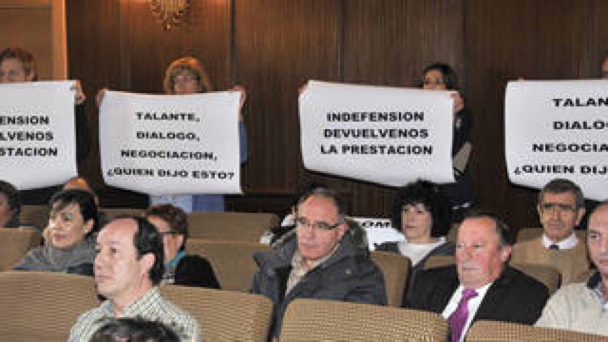 Trabajadores municipales portan pancartas pidiendo una negociación del seguro médico durante el debate plenario sobre este asunto. / V.GUISANDE-