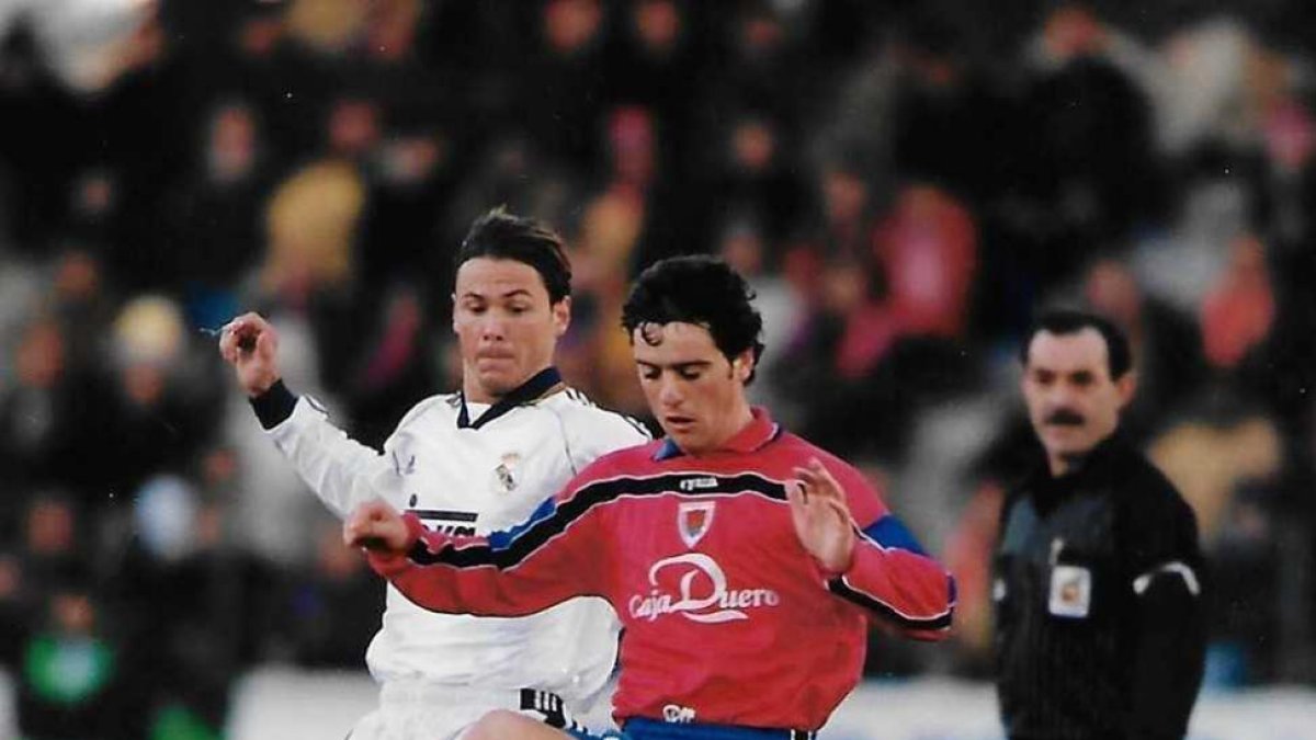 Castaño, en la imagen con el madridista Redondo, anotaba el gol de la última victoria soriana en El Sadar.-Archivo C.D. Numancia