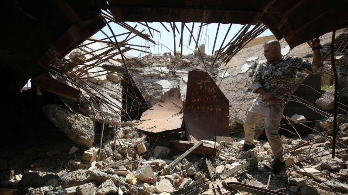 Un soldado de las Fuerzas de Movilización Popular comprueba los restos de la tumba del dictador iraquí Sadam Husein en Ouja, al sur de la ciudad de Tikrit.-AHMAD AL-RUBAYE (AFP)