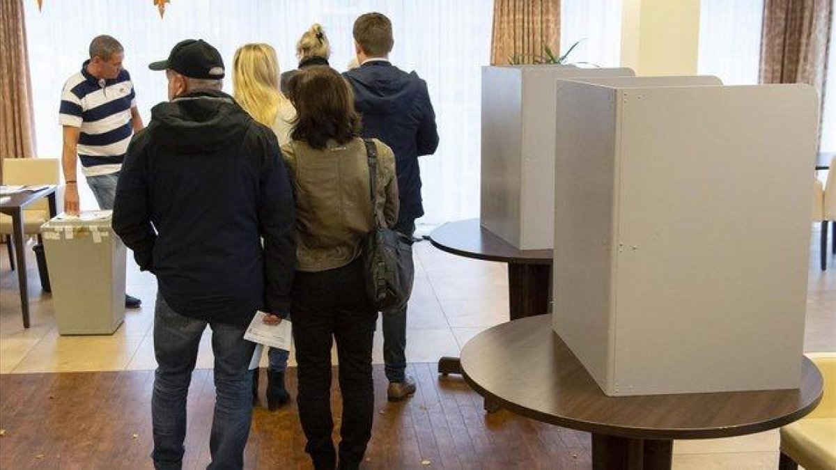 Ciudadanos de la región alemana de Turingia ejercen su derecho a voto en Erfurt.-